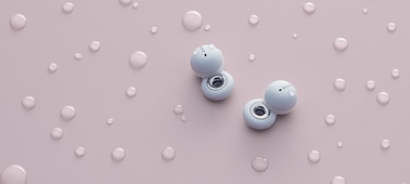 LinkBuds blancos sobre un fondo rosa con gotas de agua